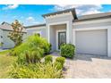 Home exterior with lush landscaping, leading to a welcoming front door and attached garage at 17618 Cortes Creek Blvd, Spring Hill, FL 34610