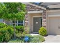 Charming entrance with stone accents, lush landscaping, and a welcoming front door at 18428 Malinche Loop, Spring Hill, FL 34610