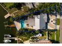 Aerial view of a waterfront home with a pool, boat dock, lush landscaping, and a metal roof at 1857 Bayou Grande Ne Blvd, St Petersburg, FL 33703