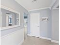 Hallway features wood flooring, mirror, and white doors with access to other rooms in the house at 2132 Academy Dr, Clearwater, FL 33764