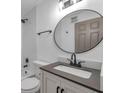 Modern bathroom features a round mirror, updated fixtures, and subway tile in shower and tub area at 2353 Shelley St # 6, Clearwater, FL 33765