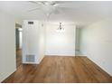 Bright living room featuring wood floors, fan, and light fixture at 2447 Ecuadorian Way # 11, Clearwater, FL 33763