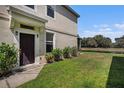 Inviting front entrance with a dark-colored door, small garden and well-kept lawn at 2542 Glenrise Pl, Wesley Chapel, FL 33544