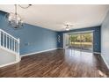 Open living room with hardwood floors and sliding glass doors leading to a screened patio at 2542 Glenrise Pl, Wesley Chapel, FL 33544