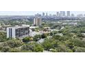 Aerial view showcasing the building's location amongst lush greenery with the city skyline in the distance at 3211 W Swann Ave # 605, Tampa, FL 33609