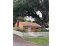 Traditional home with a well-kept lawn, mature tree, and white picket fence at 345 21St S Ave, St Petersburg, FL 33705
