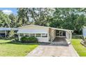Inviting single-story home with a covered carport and mature landscaping at 3542 Castle Dr, Zephyrhills, FL 33540
