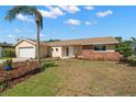 Inviting single-story home featuring a manicured lawn, mature palm tree, and a mix of brick and tan siding at 3932 Shore Acres Ne Blvd, St Petersburg, FL 33703