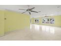 Open-concept living area featuring terrazzo floors, ceiling fans, and large windows overlooking the canal at 3932 Shore Acres Ne Blvd, St Petersburg, FL 33703