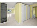 Spacious living room with yellow walls, terrazzo floors, a ceiling fan and two closets at 3932 Shore Acres Ne Blvd, St Petersburg, FL 33703