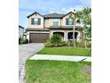 Charming two-story home featuring a stone facade, covered porch and well-manicured landscaping at 3952 Aldea Way, Wesley Chapel, FL 33543