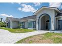 Well-maintained exterior showcases a paver driveway leading to an arched doorway with dark-gray roofing at 4012 Wellington Pkwy, Palm Harbor, FL 34685