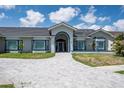 Inviting front facade with arched entryway and blue trim accents, complemented by a paver walkway at 4012 Wellington Pkwy, Palm Harbor, FL 34685