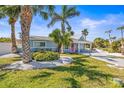 Inviting home exterior featuring vibrant landscaping and a delightful pink front door at 501 Janice Pl, Indian Rocks Beach, FL 33785