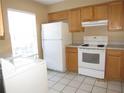 Functional kitchen with essential appliances, light wood cabinetry, and adjacent laundry area at 5110 Sunridge Palms Dr, Tampa, FL 33617