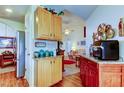 Kitchen with wood cabinets, granite counters, and views of the living room, creating an open flow at 550 Salmon Ct, Oldsmar, FL 34677