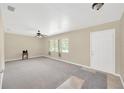 Bright living room features neutral paint, carpeted floors, large windows and ceiling fan at 6104 Palm Ave, Gibsonton, FL 33534