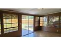 Bright sun room with multiple windows and a sliding glass door at 6825 Hammock Rd, Port Richey, FL 34668