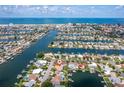 Expansive aerial view of waterfront homes with boat docks along canals leading to the ocean at 710 116Th Ave, Treasure Island, FL 33706