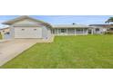 Lovely one-story home with a well-maintained lawn, attached garage, and white roof at 710 116Th Ave, Treasure Island, FL 33706