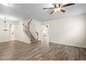 Bright living room featuring hardwood floors, ceiling fan, and staircase at 7249 Bridgeview Dr, Wesley Chapel, FL 33545