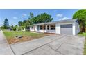 Charming one story home featuring a covered entry and an attached one car garage with a long drive at 7500 16Th N St, St Petersburg, FL 33702
