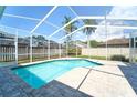 Inviting screened-in pool area with brick pavers, perfect for relaxing and entertaining in a private backyard setting at 10219 Millport Dr, Tampa, FL 33626
