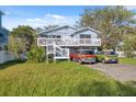 Charming two-story home with a spacious front deck and well-maintained yard with parking for multiple cars at 108 Shore Dr, Tarpon Springs, FL 34689