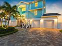 Charming coastal home with three-car garage, manicured landscaping, and a paver driveway at 11000 8Th E St, Treasure Island, FL 33706