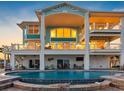 Luxury home featuring a large swimming pool, spacious patio area, and multiple balconies overlooking the water at 11000 8Th E St, Treasure Island, FL 33706