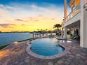 Beautiful pool with stone surround offers tranquil waterfront views and lush backyard landscaping at 11000 8Th E St, Treasure Island, FL 33706