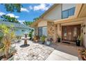 Charming front courtyard with a decorative fountain, lush plants, and a beautiful double-door entrance at 11974 Rosetree S Pl, Seminole, FL 33772
