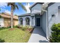 Inviting home entrance with arched windows, gray walkway, and lush landscaping at 12510 Sparkleberry Rd, Tampa, FL 33626