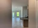 Bright, open-concept living room featuring tile flooring, neutral walls, and plenty of natural light from large windows at 13187 Ogden Glade Rd, Dade City, FL 33525