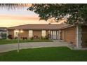 Warm exterior view of a single story home with a lush green lawn at sunset at 14564 110Th Ter, Largo, FL 33774