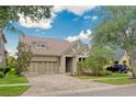 Charming home with a well-manicured front yard, brick driveway, and a convenient two-car garage at 14610 Mondavi Ct, Tampa, FL 33626