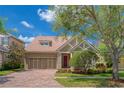 Beautiful single-Gathering home featuring a well-maintained lawn, brick driveway, and a two-car garage at 14610 Mondavi Ct, Tampa, FL 33626