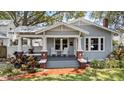 Inviting home front with a covered porch featuring rocking chairs and a brick walkway at 212 W Powhatan Ave, Tampa, FL 33604