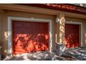 Two-car garages with red doors and stone accents, offering convenient parking at 2173 Tuscany Trce # 8, Palm Harbor, FL 34683