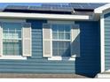 Close-up of a home exterior showing the siding, windows, and solar panels at 2325 Via Bella Blvd, Land O Lakes, FL 34639