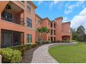 Condo building with mature landscaping, charming walkway, and views of private balconies at 2705 Via Murano # 127, Clearwater, FL 33764