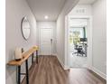 Hallway featuring hardwood floors, modern decor and leads into an office space with large window at 30273 Marquette Ave, Wesley Chapel, FL 33545