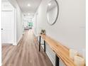 Bright hallway featuring hardwood floors and modern decor leading into the living area at 30273 Marquette Ave, Wesley Chapel, FL 33545