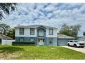 Charming two-story home featuring a well-manicured lawn and attached two car garage at 3181 Deltona Blvd, Spring Hill, FL 34606