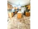 Spacious kitchen featuring an island, granite countertops, stainless appliances, and tile backsplash at 3181 Deltona Blvd, Spring Hill, FL 34606