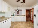 Well-lit kitchen with white cabinetry, granite countertops, and modern appliances with a view to the living space at 3321 14Th N St, St Petersburg, FL 33704