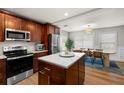 Well-equipped kitchen with stainless steel appliances, dark wood cabinets, and center island with white countertop at 4208 W Bay Vista Ave, Tampa, FL 33611