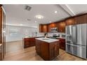 Spacious kitchen featuring dark wood cabinetry, stainless steel appliances, and center island with granite countertops at 4208 W Bay Vista Ave, Tampa, FL 33611