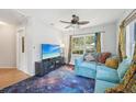 Inviting living room with galaxy carpet, comfy blue sectional, and large windows with colorful curtains at 4801 71St N St, St Petersburg, FL 33709