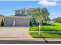 Two-story home featuring a well-manicured lawn, and three-car garage, on corner lot at 4805 Holdsworth Dr, Land O Lakes, FL 34639